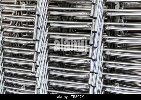 Close-up di tre pile di alluminio lucido sedie tubolare Foto Stock