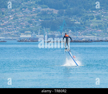 Giovane uomo gode di praticare flyboard nel pomeriggio del ría de Vigo in Spagna Foto Stock