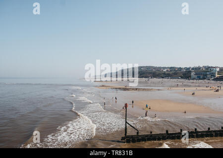 Cromer, Regno Unito - 20 Aprile 2019: le persone che si godono la giornata di sole su una spiaggia a Cromer, una cittadina balneare nel Norfolk e una famiglia popolare meta di vacanza nel Regno Unito. Foto Stock