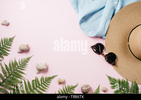 Femminile moda estiva composizione con camicetta, cappello, occhiali da sole, felce, il Seashell su sfondo rosa. Appartamento laico, vista dall'alto vestiti minimalista collage. Tr Foto Stock