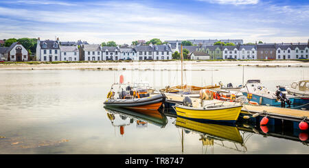 Porto con le barche in acqua tranquilla a Port Ellen, Isle of Islay, Scozia Foto Stock