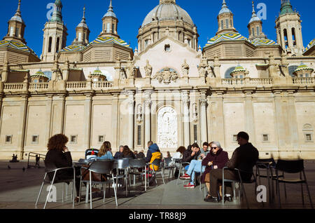 Saragozza, Aragona, Spagna : persone sedersi in un caffè all'aperto accanto alla facciata barocca della Basilica della Madonna del Pilastro in Plaza del Pilar squa Foto Stock