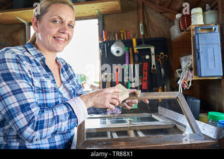 Ritratto di donna matura Upcycling mobili in officina a casa Foto Stock