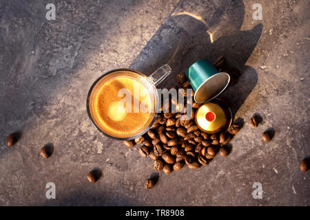 Scatti espresso con i chicchi di caffè e un bicchiere riempito con caffè espresso Foto Stock