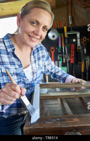 Ritratto di donna matura Upcycling mobili in officina a casa armadio dipinto Foto Stock