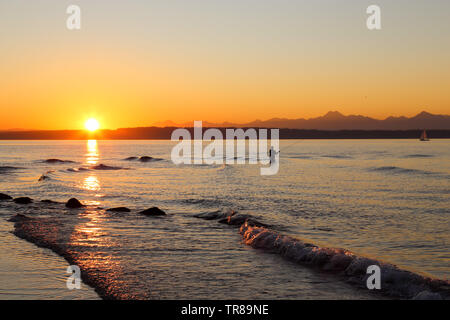 Un pescatore è la pesca Golden gardens park, Seattle, Washington durante un magnifico tramonto Foto Stock