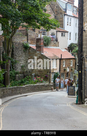 Il turista a godere le pittoresche strade strette, Robin Hood's Bay, North Yorkshire, Regno Unito Foto Stock