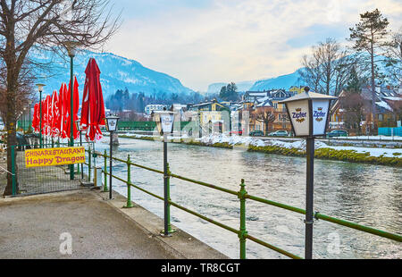 BAD Ischl Austria - 20 febbraio 2019: a piedi lungo argine del fiume Traun con lanterne vintage e terrazze estive di caffè, il 20 febbraio a Bad Foto Stock