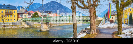 Godetevi il parco in Traunkai argine del fiume Traun con una vista sul ponte Taubersteg e alloggiamento di Bad Ischl, Salzkammergut, Austria Foto Stock