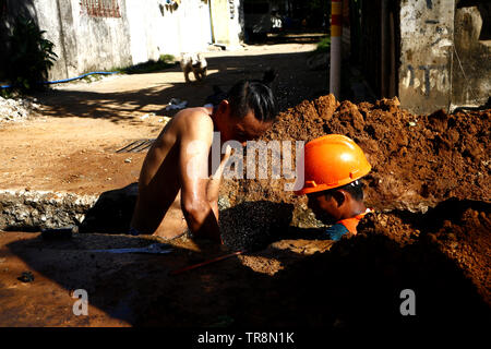 ANTIPOLO City, Filippine - 30 Maggio 2019: lavoratori edili installare nuovi tubi di acqua lungo una strada pubblica. Foto Stock