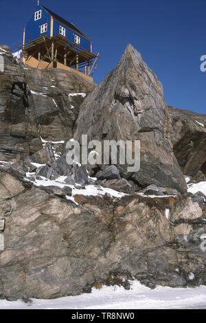 Casa costruita su palafitte sulla sommità di una rupe di UUMMANNAQ, Groenlandia. Foto Stock