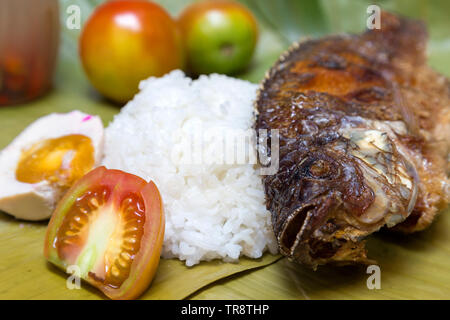 Filippini piatto tradizionale: fritto philippine tilapia pesce con riso Foto Stock