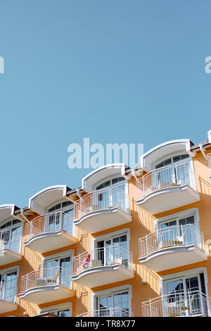 Vacanza moderno di color pesca appartamenti con balconi e cielo blu Foto Stock