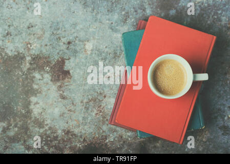 Libri e tazza di caffè su un sfondo Grunge Foto Stock