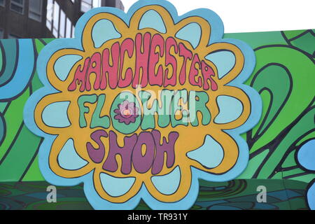 La Manchester Flower Show, parte di Manchester's King Street Festival il 1 giugno - 2nd, 2019, si prepara ad aprire. Il tema di quest'anno:Flower Power! Un grande cartello d'ingresso di King Street, accoglie i visitatori. Foto Stock