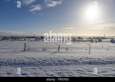 Tipica vista inverno attraverso un meraviglioso paesaggio in Islanda verso il sole al tramonto. Foto Stock