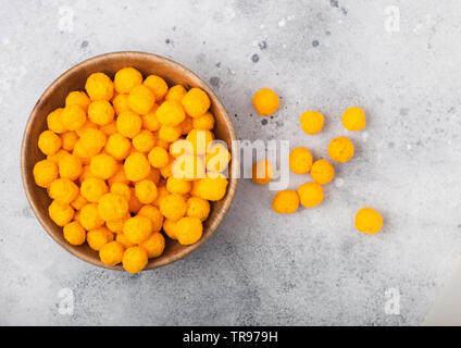 Golden soffiato palline di formaggio come classico snack per bambini sul tavolo luminoso. Vista superiore Foto Stock