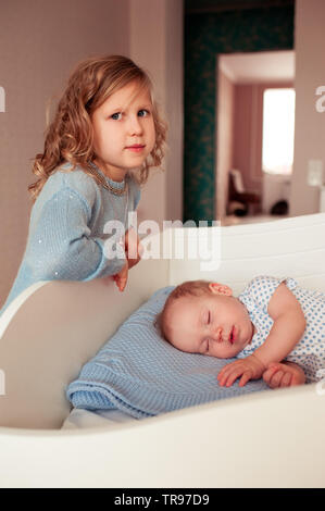 Kid girl 4-5 anno vecchio con bambino 1 anni nella camera da letto. Infanzia. Foto Stock