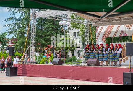 La Bulgaria 31 Maggio 2019: Adulti folklore canzone di gruppi di tutte le età, i bambini dei gruppi di danza collegato via bus da scuole e gruppi di ballo in tutta la regione Yambol indossando il costume tradizionale abito da loro regionale. Divertito locali visita turistica e appassionati di folklore durante la canzone Elhovo e dance festival . Clifford Norton Alamy Foto Stock