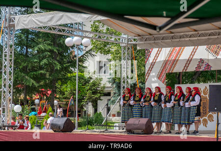 La Bulgaria 31 Maggio 2019: Adulti folklore canzone di gruppi di tutte le età, i bambini dei gruppi di danza collegato via bus da scuole e gruppi di ballo in tutta la regione Yambol indossando il costume tradizionale abito da loro regionale. Divertito locali visita turistica e appassionati di folklore durante la canzone Elhovo e dance festival . Clifford Norton Alamy Foto Stock