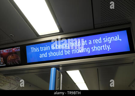 "Questo treno viene mantenuto ad un segnale rosso e deve essere in movimento a breve " segno su un vagone ferroviario a causa di interruzioni del servizio in Londra England Regno Unito Foto Stock