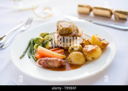 Un arrosto di Natale la cena con un cracker in background Foto Stock