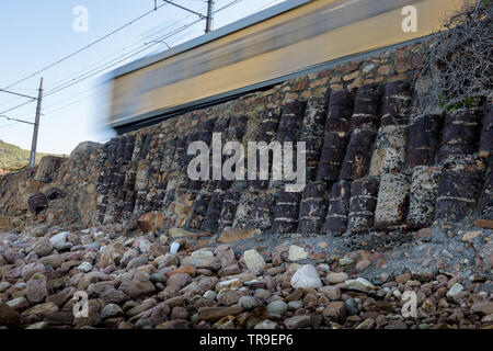 La linea ferroviaria tra Muizenberg e la Simons Town segue la falsa costa della baia di Cape Peninsula, vicino a Città del Capo in Sud Africa Foto Stock