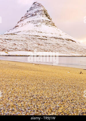 Vista della Montagna Kirkjufell alla moda sulla spiaggia in Islanda al tramonto in inverno. Foto Stock