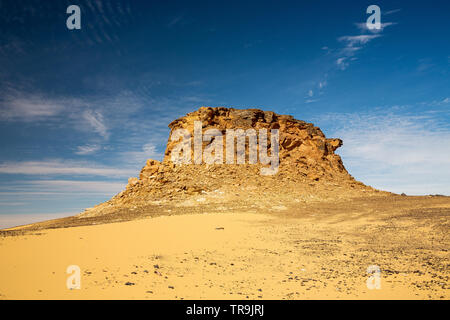 Jebel picco, uno sbriciolamento di montagna in pietra arenaria, un isolato circondato dal piatto deserto occidentale del Sudan con cielo blu e bianco delle formazioni di nubi, Foto Stock