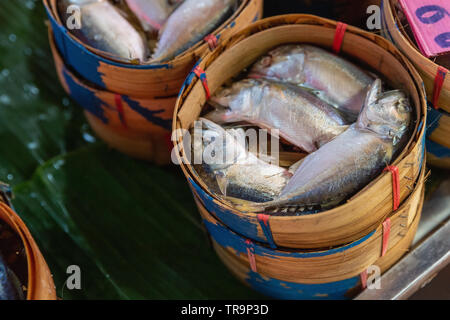 Cesto in legno di pesce per la vendita presso il Maeklong mercato ferroviario, Bangkok, Thailandia Foto Stock