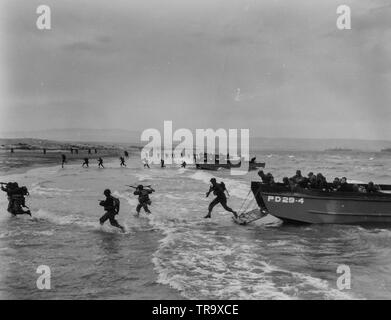 Invasori ha colpito la terra in manovre di Invasione - truppe americane, portando i fucili e luce attrezzature di estinzione, la molla attraverso il surf dalla Coast Guard-manned landing craft in finale le manovre di anfibio da qualche parte sulla costa nord africana. Invasori e Guardia Costiera invasione craft, come questi, ha colpito le spiagge della Normandia francese prima dell'ALBA D-Day Foto Stock