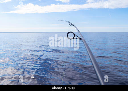 Canna da pesca anello di filatura con la linea di close-up. Canna da pesca oltre il cristallo ancora l'acqua. Canna da pesca anelli. Attrezzatura da pesca. La pesca mulinello. Foto Stock