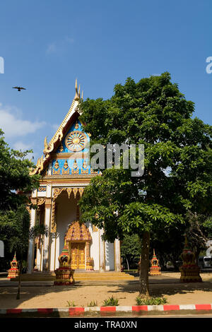 Una colomba vola passato un piccolo tempio buddista. Accanto al Wat Tham Suwan Khuha. Foto Stock