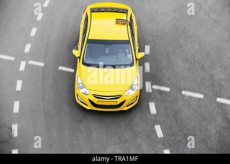 Taxi giallo si muove sulla strada di città Foto Stock