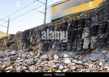 La linea ferroviaria tra Muizenberg e la Simons Town segue la falsa costa della baia di Cape Peninsula, vicino a Città del Capo in Sud Africa Foto Stock