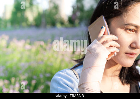 giovani studentesse che chiamano gli smartphone mentre il dolore alla mano del polso. stile di vita moderno Foto Stock