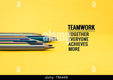 Il lavoro di squadra concetto. gruppo di matita colorata su sfondo giallo con word il lavoro di squadra, insieme, tutti, raggiunga e altro ancora Foto Stock