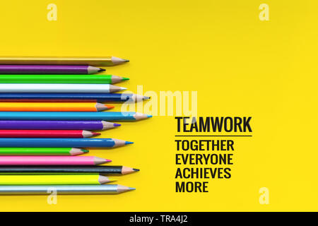 Il lavoro di squadra concetto. gruppo di matita colorata su sfondo giallo con word il lavoro di squadra, insieme, tutti, raggiunga e altro ancora Foto Stock