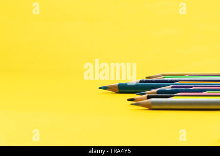 Leadership il concetto di business. Colore blu matita altri colori su sfondo giallo Foto Stock