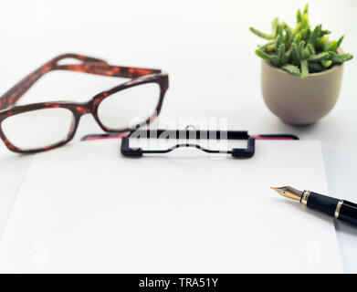 Business Objects, appunti con foglio di carta bianco, penna, occhiali su sfondo bianco Foto Stock