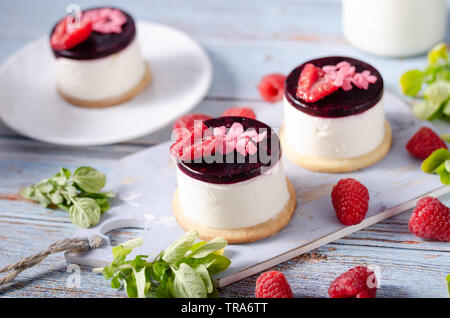 Fresco e semplice dessert con frutti di bosco freschi, cioccolato fondente cookie sul top e fresche creame in medio Foto Stock