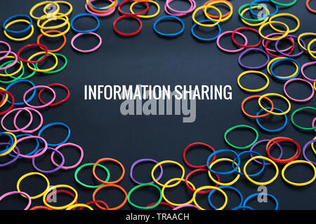 Condivisione delle informazioni concetto, gomma colorata banda di parola con la condivisione di informazioni su sfondo nero Foto Stock