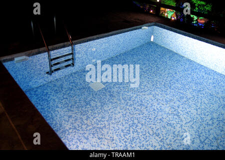 Piscina di notte in serata con acqua sotto le luci. Bagno di notte per concept vacanze relax in viaggio. Pool pronto per il nuoto con le luci della notte. Foto Stock