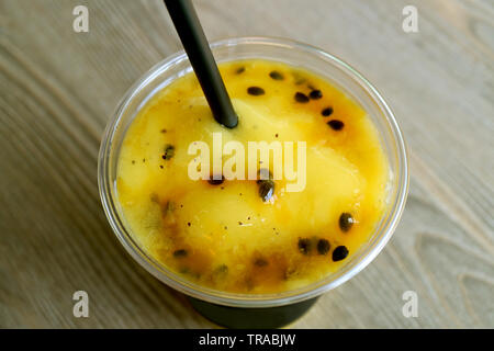Bicchiere di succulenti Mango con passione frullato di frutta sul tavolo di legno Foto Stock