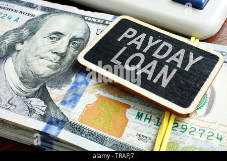 Payday Loan concetto. Pila di fatture del dollaro sulla scrivania. Foto Stock