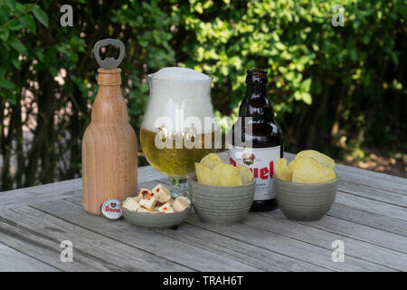 Sint Gillis waas, Belgio - 22 luglio 2018: Duvel, Belgio birra formaggio feta e patatine salate e un di legno apribottiglie a forma di bottiglia di duve Foto Stock