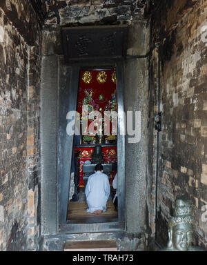 Una persona adora presso un altare indù. Cham Torre. Nha Trang, Viet Nam Foto Stock