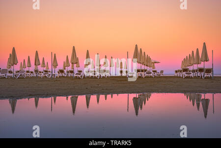 Palme e lettini presso la spiaggia sabbiosa di Larnaca, Cipro Foto Stock