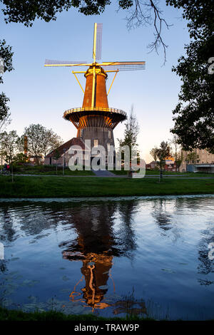 Il mulino a vento de Valk in Leiden incorniciata tra foglie di albero, Olanda Foto Stock