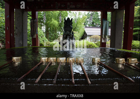 Un chōzuya o temizuya, lo shintoismo acqua abluzione pavilion al Fuji Kitaguchihongu Asama Santuario in Fujiyoshida, prefettura di Yamanashi in Giappone. Foto Stock